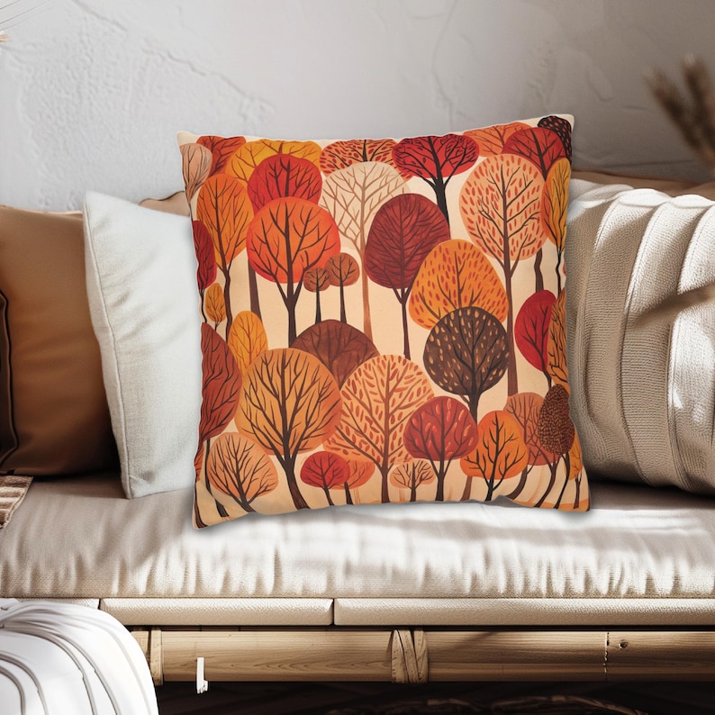 May include: A throw pillow with a colorful autumn forest design. The pillow features a pattern of trees with orange, red, and brown leaves.
