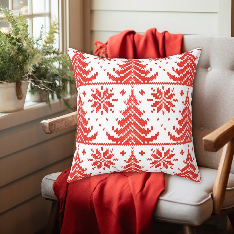 May include: Red and white cushion with a knitted Christmas tree and snowflake pattern.