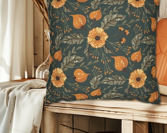 Op de afbeelding: Een decoratief kussen met een donkergroene achtergrond en een bloemenpatroon met oranje bloemen en bladeren.