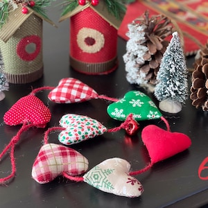Peut inclure: Une guirlande de cœurs en tissu à motifs rouges et blancs à carreaux, rouges et verts, rouges et verts et blancs avec un cordon rouge. La guirlande est suspendue sur une surface noire avec le chiffre 6 écrit sur la surface.