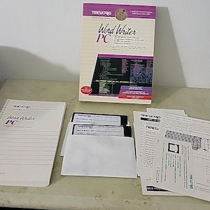Może przedstawiać: Pakiet oprogramowania TimeWorks Word Writer PC w stylu vintage, zawierający pudełko, instrukcje i dyskietki. Pudełko jest biało-fioletowe, z nazwą oprogramowania dużymi literami. Instrukcje i dyski są biało-czarne.
