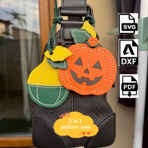 Puede incluir: Un conjunto de colgantes con forma de calabaza y pera, con segmentos naranjas y amarillo-verdosos y costuras visibles. La calabaza tiene una cara de jack-o'-lantern tallada. Un gráfico amarillo muestra el texto 2 in 1 pattern sale.