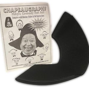 May include: A black felt chapeaugraphy hat next to a printed instruction sheet. The sheet features the title "CHAPEAUGRAPHY Magic Comedy Hat Act" and illustrations of various hats. The hat is a curved, crescent-shaped piece of felt.