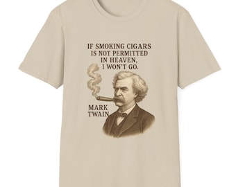 May include: A beige t-shirt with a quote by Mark Twain: "If smoking cigars is not permitted in heaven, I won't go." The quote is printed in black text and features a vintage illustration of Mark Twain smoking a cigar.
