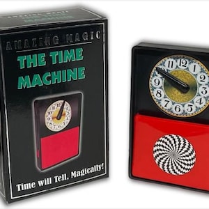 May include: A black box with the words "Amazing Magic" and "The Time Machine" printed on it. The box contains a magic trick with a clock face and a red and black swirling pattern.