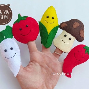 May include: A hand wearing five felt finger puppets shaped like smiling vegetables: a red tomato, a yellow corn, a brown mushroom, a white radish, and a red chili pepper. The puppets have black button eyes and are smiling. Text in the upper left corner reads "PDF & SVG PATTERN".