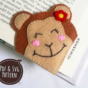 May include: A brown felt monkey bookmark with a red flower on its head. The monkey has a smiling face with pink cheeks and closed eyes. The bookmark is labeled "PDF & SVG PATTERN" and "ICIKUSHOP".