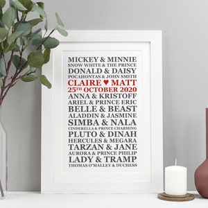 May include: A white framed print with a black and red design featuring a list of Disney couples with their names and the date "25th October 2020" in red. The names "Claire" and "Matt" are also in red with a heart symbol between them.