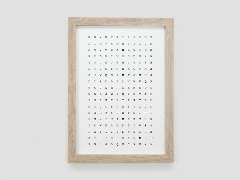 K&ouml;nnte beinhalten: Ein gerahmter Druck mit wei&szlig;em Hintergrund und schwarzem Text. Der Text ist in einem Raster angeordnet und enth&auml;lt die Buchstaben des Alphabets. Der Rahmen ist aus hellem braunem Holz.