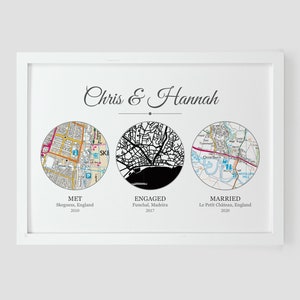May include: A black and white map print with three circles showing the locations where a couple met, got engaged, and married. The text reads "Chris & Hannah" and includes the locations and years of each event.