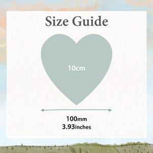 K&ouml;nnte beinhalten: Eine Gr&ouml;&szlig;entabelle mit einem hellblauen Herz. Das Herz ist mit "10cm" beschriftet und die Breite wird mit "100mm" und "3.93 inches" angegeben. Der Text "Size Guide" steht oben.