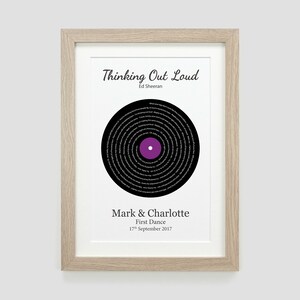 May include: A framed print of a black vinyl record with the lyrics to the song "Thinking Out Loud" by Ed Sheeran printed in a circle around the center. The text "Mark & Charlotte First Dance 17th September 2017" is printed below the record.