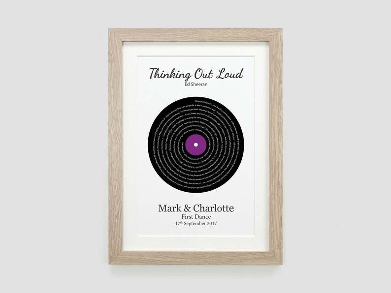 May include: A framed print of a black vinyl record with the lyrics to the song "Thinking Out Loud" by Ed Sheeran printed in a circle around the center. The text "Mark & Charlotte First Dance 17th September 2017" is printed below the record.