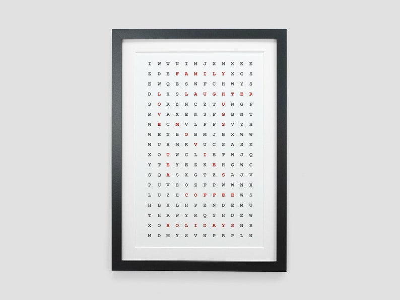 K&ouml;nnte beinhalten: Ein schwarzer gerahmter Druck mit wei&szlig;em Hintergrund und einem Gitter aus Buchstaben. Die W&ouml;rter "FAMILY", "LAUGHTER", "LOVE", "TEA", "COFFEE" und "HOLIDAYS" sind rot hervorgehoben.