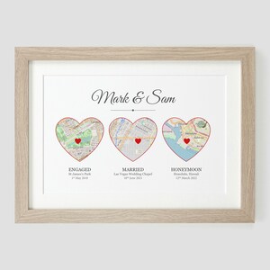 Pu&ograve; includere: Una stampa incorniciata con tre mappe a forma di cuore che rappresentano luoghi diversi. Il testo "Mark & Sam" &egrave; in cima alla stampa. La prima mappa a forma di cuore &egrave; etichettata "Fidanzati" con la posizione "St. James's Park, Londra" e la data "1 maggio 2018". La seconda mappa a forma di cuore &egrave; etichettata "Sposati" con la posizione "Las Vegas Wedding Chapel" e la data "18 giugno 2021". La terza mappa a forma di cuore &egrave; etichettata "Luna di miele" con la posizione "Honolulu, Hawaii" e la data "12 marzo 2022".