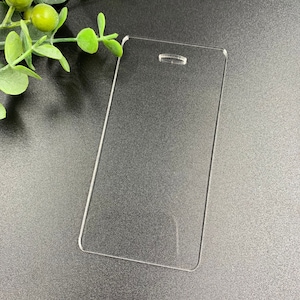 May include: A clear plastic badge holder with a hole at the top for a lanyard. The holder is rectangular and has rounded corners.