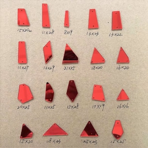 May include: Assortment of red mirrored glass shapes in various sizes. The shapes include triangles, rectangles, and diamonds. The sizes are listed in inches.