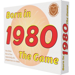 May include: A game box with a red and yellow design. The box features the text "Born in 1980 The Game" and a heart with the year 1980 inside. The text "A New Card Game For People Born In 1980" is on the side of the box.