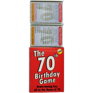 May include: A red box with the text "The 70th Birthday Game" and the tagline "Brain-teasing fun, all on the theme of 70". The box contains a set of cards with trivia questions about events that happened in the year 1981, 1986, and 1991.