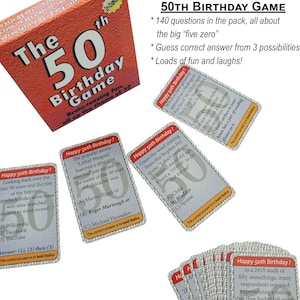 May include: A 50th birthday game with a red box and several cards. The cards have a white background with black text and a gray pattern. The text on the cards includes "Happy 50th Birthday!" and questions about the 50th birthday. The box has the text "The 50th Birthday Game" on it.