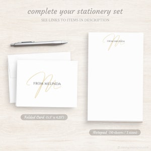 May include: A set of personalized stationery featuring a handwritten script "M" with the text "From Melinda" in a beige color. The set includes a folded card measuring 5.5 inches by 4.25 inches and a notepad with 50 sheets in two sizes.