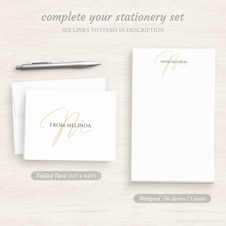 May include: A set of personalized stationery featuring a handwritten script "M" with the text "From Melinda" in a beige color. The set includes a folded card measuring 5.5 inches by 4.25 inches and a notepad with 50 sheets in two sizes.