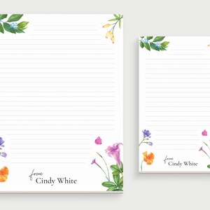 May include: Two lined notepads with floral designs and the text "from Cindy White" at the bottom. The larger notepad has a blue and green floral design at the top and a purple, orange, and pink floral design at the bottom. The smaller notepad has a similar floral design at the top and bottom.