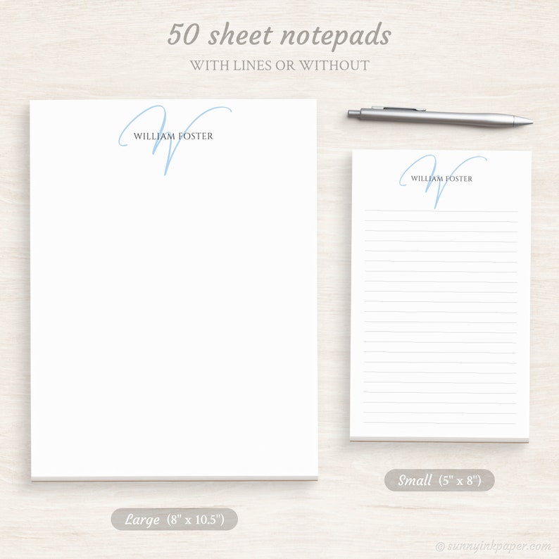 May include: Two white notepads with a blue script initial "W" and the name "William Foster" printed on them. The notepad on the left is larger, measuring 8 inches by 10.5 inches. The notepad on the right is smaller, measuring 5 inches by 8 inches. Both notepads have 50 sheets and are available with or without lines.