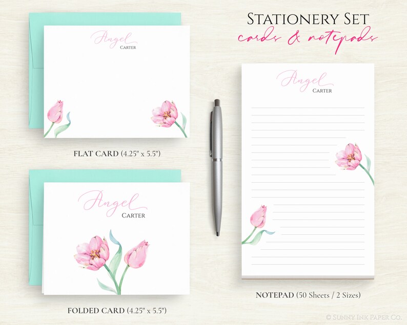 May include: A stationery set featuring a pink tulip design. The set includes a flat card, a folded card, and a notepad. The cards measure 10.8 cm by 14 cm. The notepad has 50 sheets and comes in two sizes. The text on the cards and notepad reads "Angel Carter".