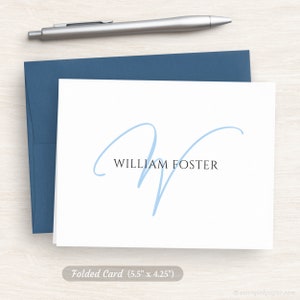 May include: A folded white card with a light blue cursive letter W and the text "WILLIAM FOSTER" printed in black.