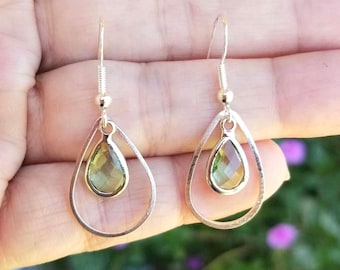 Puede incluir: Un par de pendientes de plata con una piedra preciosa verde en forma de lágrima en cada pendiente.