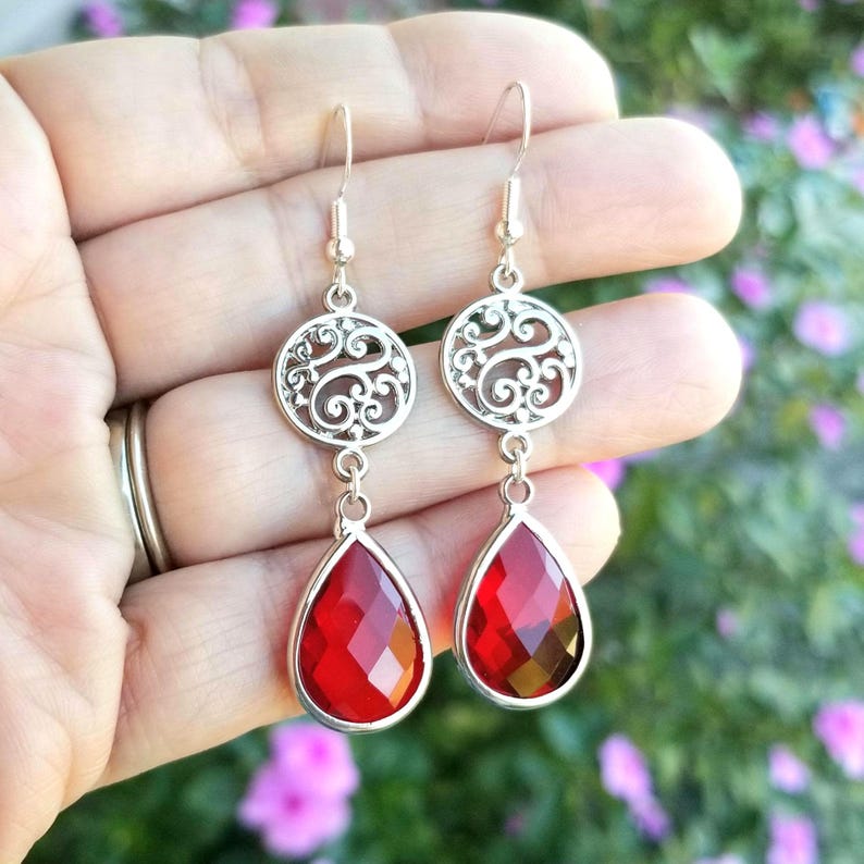 以下が含まれることがあります： 赤い雫型のクリスタルが付いた銀のフィリグリーイヤリング