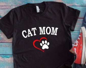 May include: Black t-shirt with the text "CAT MOM" in white letters and a red heart with a white paw print.