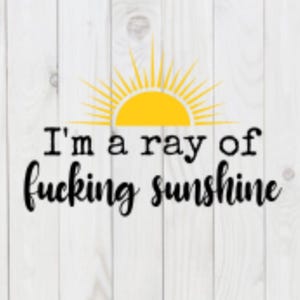 Op de afbeelding: Een gele zon met stralen op een witte houten achtergrond met de tekst "I'm a ray of fucking sunshine".