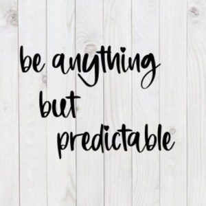 May include: Black and white typography on a white wood background. The text reads "be anything but predictable".