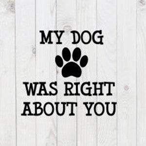 May include: Black text on a white wooden background reads "MY DOG WAS RIGHT ABOUT YOU" with a black paw print symbol between the phrases. The text is in a bold, sans-serif font.