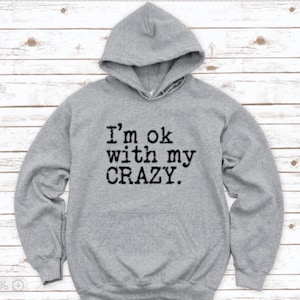 May include: Gray hooded sweatshirt with the text "I'm ok with my CRAZY." printed in black.