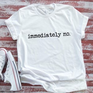 May include: White t-shirt with the text "immediately no." printed in black.