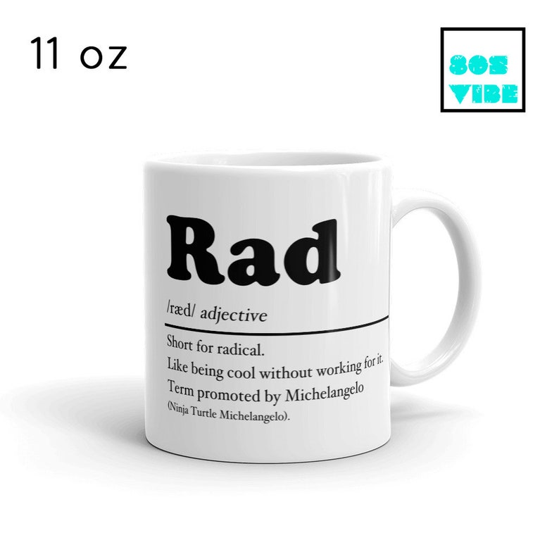 May include: White ceramic mug with a black and white design. The mug features the word "Rad" in bold black letters, followed by a definition of the word. The definition reads: /r&aelig;d/ adjective Short for radical. Like being cool without working for it. Term promoted by Michelangelo (Ninja Turtle Michelangelo).