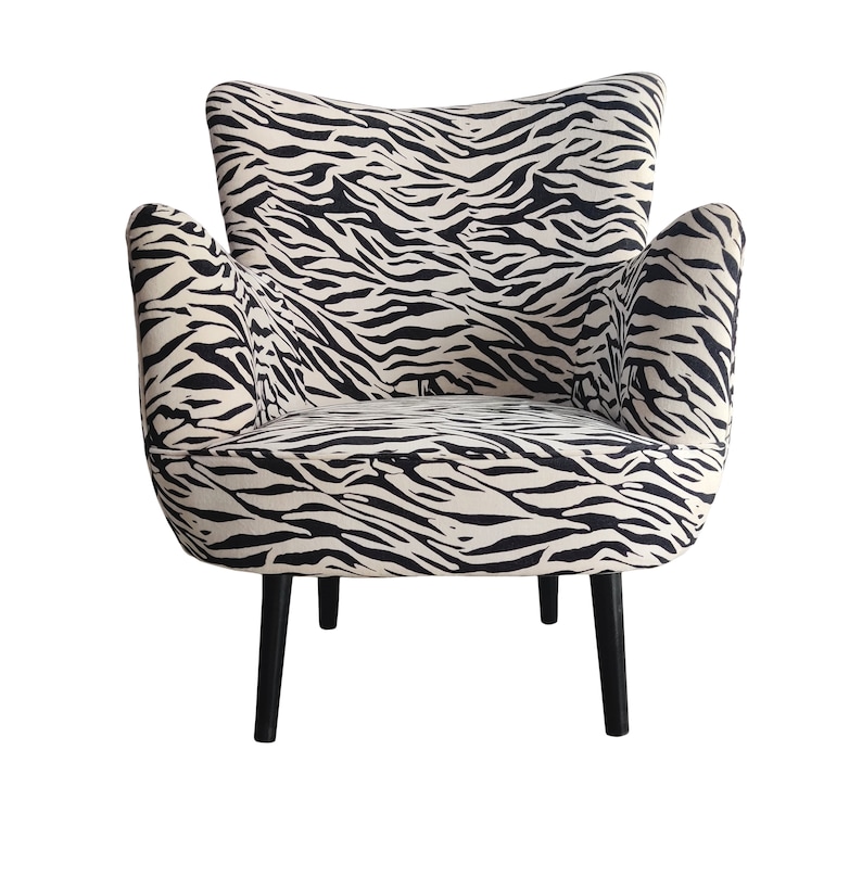 May include: A black and white zebra print armchair with black wooden legs.