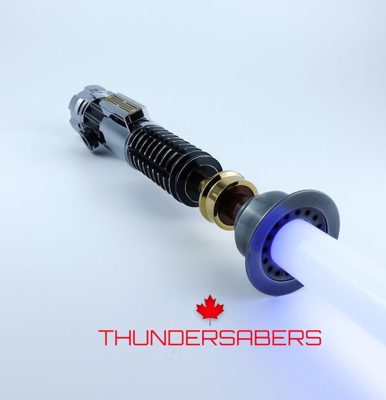 May include: A detailed lightsaber with a silver, black, and gold hilt and a white blade emitting a blue glow. The text "THUNDERSABERS" is displayed in red below the lightsaber, along with a red maple leaf.