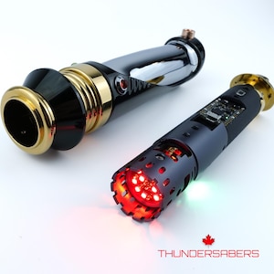 Puede incluir: Dos sables de luz futuristas. Uno es negro, dorado y cromado, con luz roja. El otro es negro con luz roja y una placa de circuito visible. El texto "THUNDERSABERS" est&aacute; en la parte inferior.