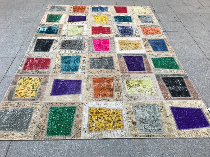 May include: A colourful patchwork rug featuring a range of colours and patterns, including red, blue, green, yellow, and purple. The rug is made from various fabrics and textures, creating a unique and eclectic style.