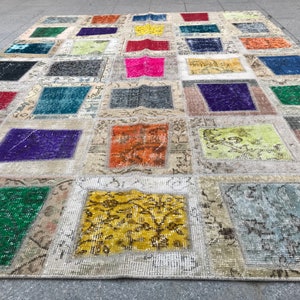 May include: A patchwork rug featuring a range of colours and patterns, including red, blue, green, yellow, and purple. The rug is crafted from various fabrics and textures, and has a distressed appearance.