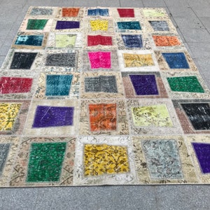 May include: A colourful patchwork rug featuring a range of colours and patterns, including red, blue, green, yellow, and purple. The rug is made from various fabrics and textures, creating a unique and eclectic style.