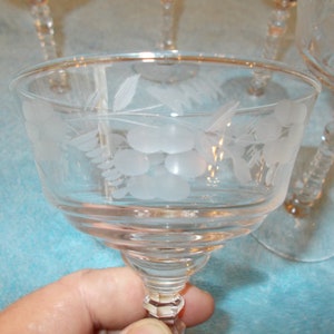 May include: Set of four clear glass stemmed dessert cups with an etched design of grapes and leaves. The cups have a delicate, feminine look.