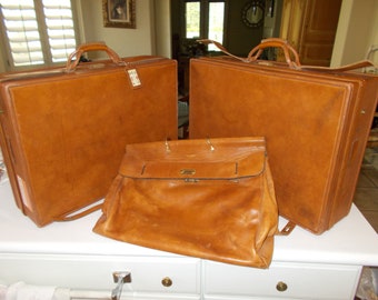 Two (2) Vintage Hartmann Pullman Large Leather Suitcases Plus one leather Saks fifth Avenue carry-on bag.