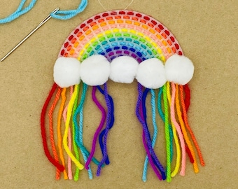 May include: A rainbow-colored yarn craft with white pom-poms representing clouds. The rainbow is made of plastic canvas and the yarn is attached to the bottom of the rainbow.