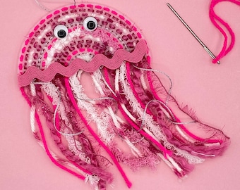 May include: Pink and white yarn jellyfish craft with googly eyes and a silver thread hanging from the top.