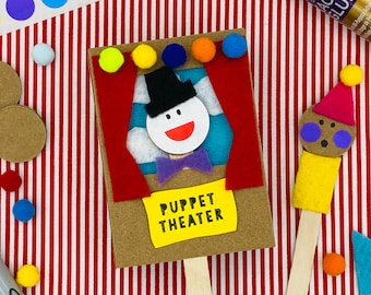 May include: A brown cardboard puppet theater with a red curtain and a white puppet with a black hat and a purple bow tie. The puppet theater has a yellow sign that says "Puppet Theater".